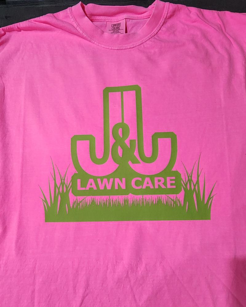 Neon pink tee with a green J&L Lawn Care logo