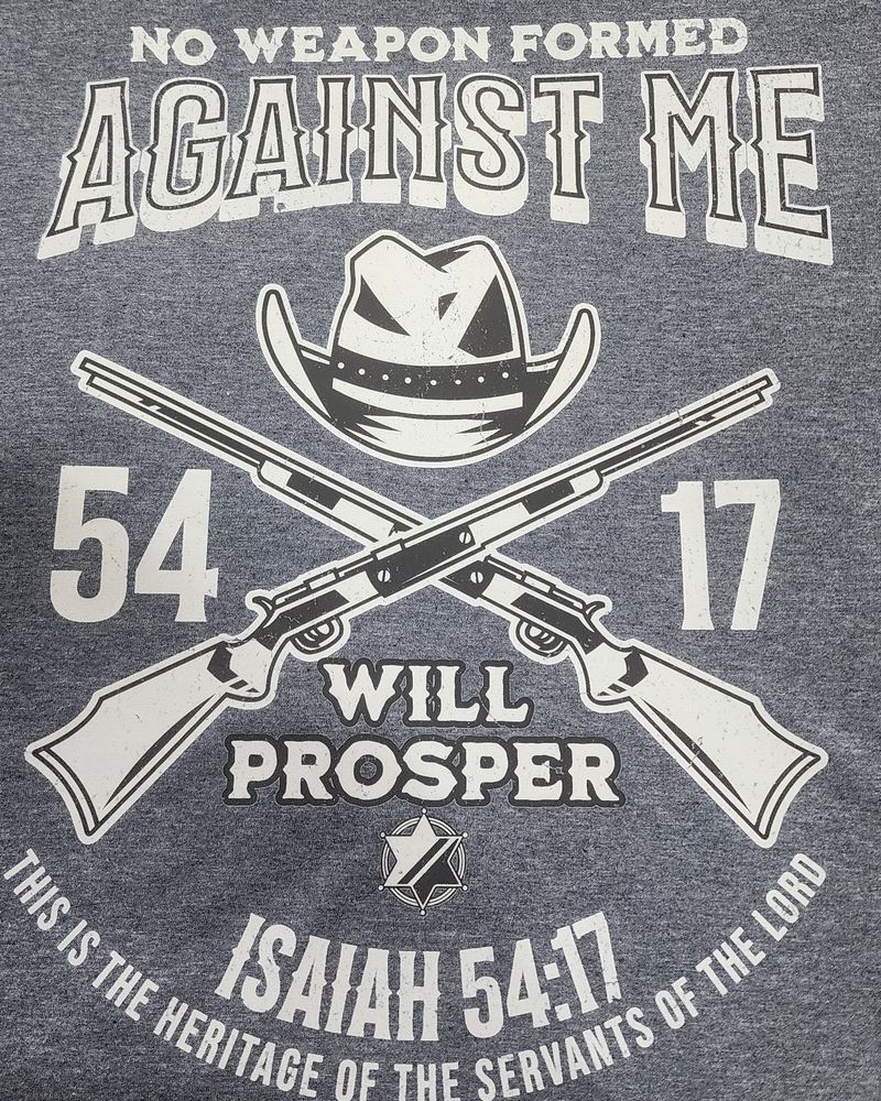 Heather navy tee reading 'No weapon formed against me will prosper, Isaiah 54:17' with a cowboy hat and crossed rifles